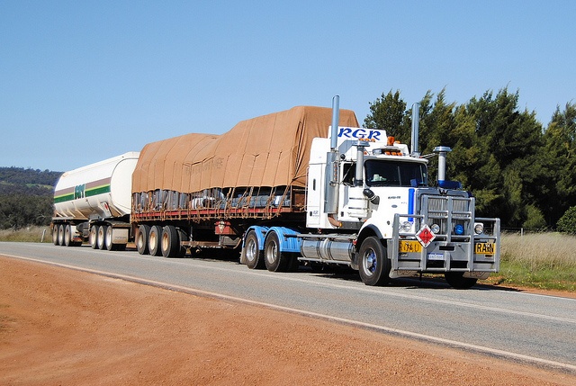 An early RGR prime mover hauling a tarped road train on a WA country highway